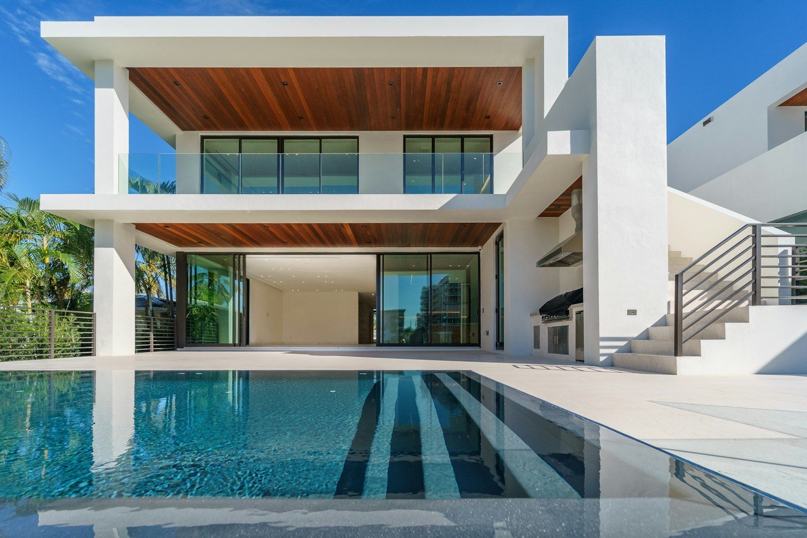 A waterfront home with a pool at dusk